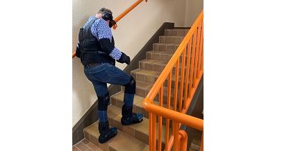Selbsterfahrung bei der Fortbildung bauliche Barrierefreiheit in Detmold im Mai 2023: ein Teilnehmer trägt einen Alterssimulationsanzug und versucht, Treppen zu steigen.