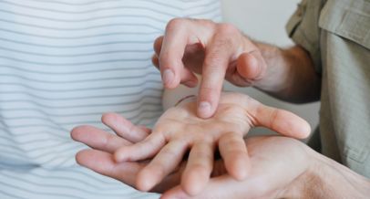 Zwei linke Hände zeigen mit den Handflächen nach oben, dabei liegt die obere Hand auf der unteren. Die rechte Hand berührt die obere Hand mit dem Zeigefinger und kommuniziert so mit dem anderen Menschen.