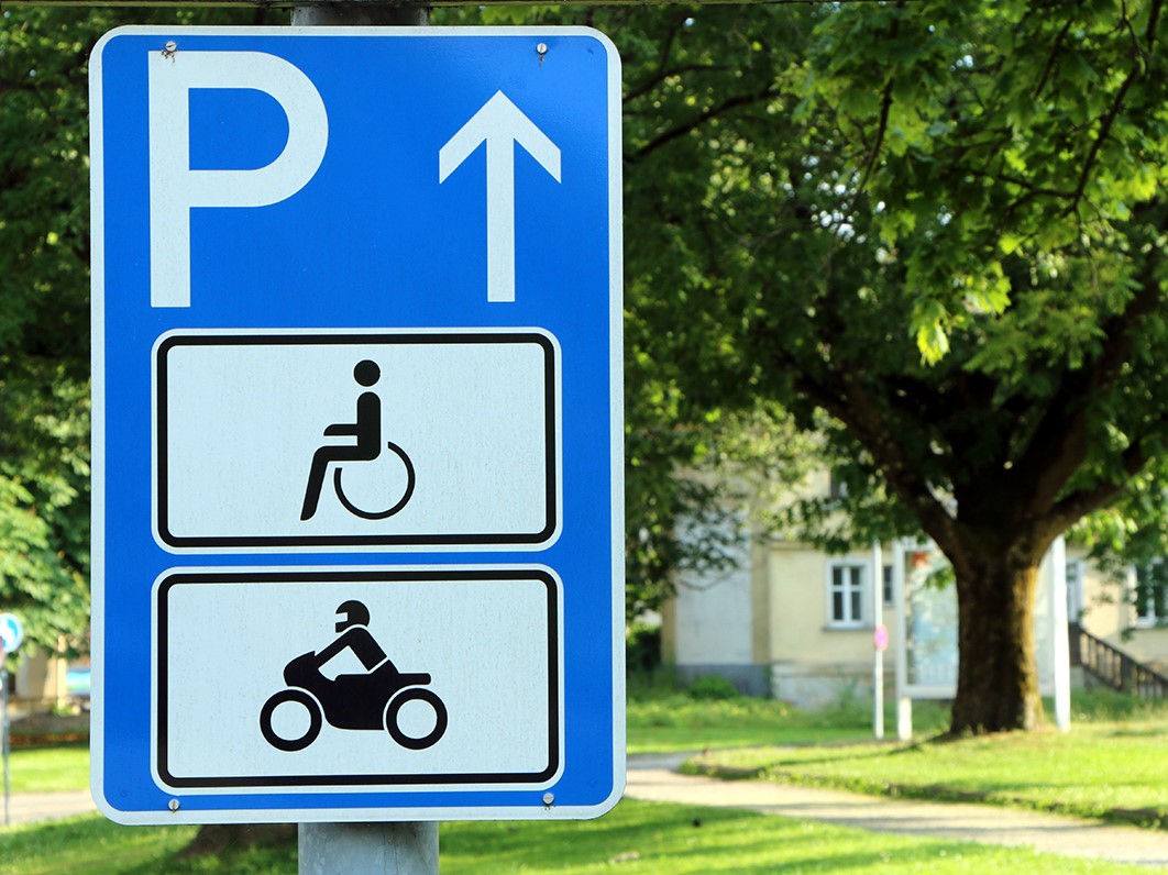 Hinweisschild für barrierefreie PKW-Stellplätze an der Einfahrt eines Parkplatzes